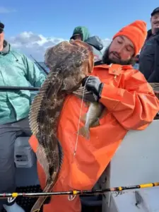 Fisherman holding large Lingcod fish catch